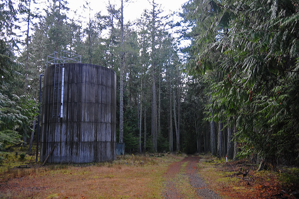 Obstruction Island community water tank by circle ring road walking path through forest trees