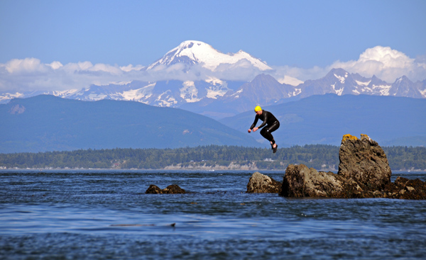 Jumping off James Island State Park rock into Puget Sound water