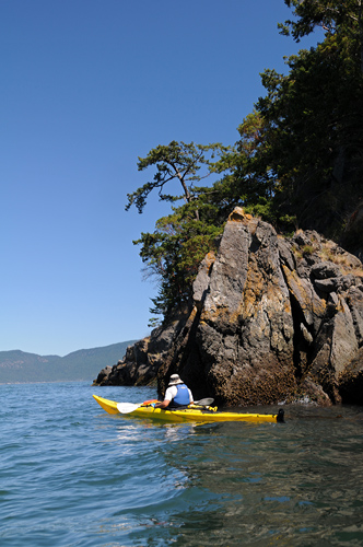 Kayaker by James Island rock formations Puget Sound San Juan Islands