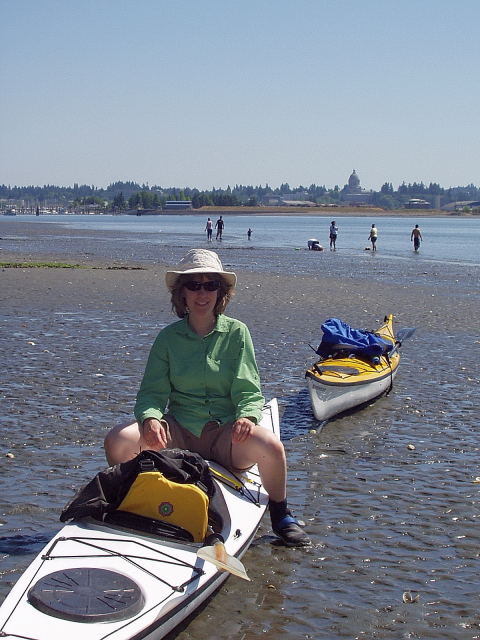 Karen On Kayak At The Beach Of Priest Point Park With State Capitol In Background, Olympia, Washington