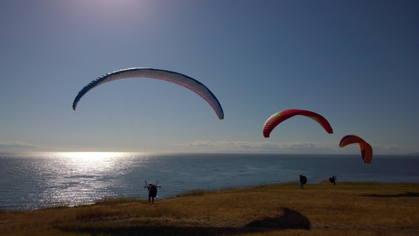 Fort Ebey State Park 3 paragliders at bluff edge overlooking Strait of Juan de Fuca