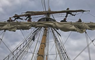 Hawaiian Chieftain crew up mast and rigging in Coupeville Penn Cove