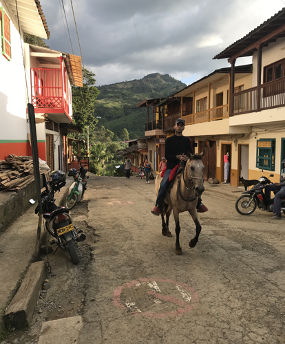 Local cowboy riding prancing horse through streets of Jardin Colombia